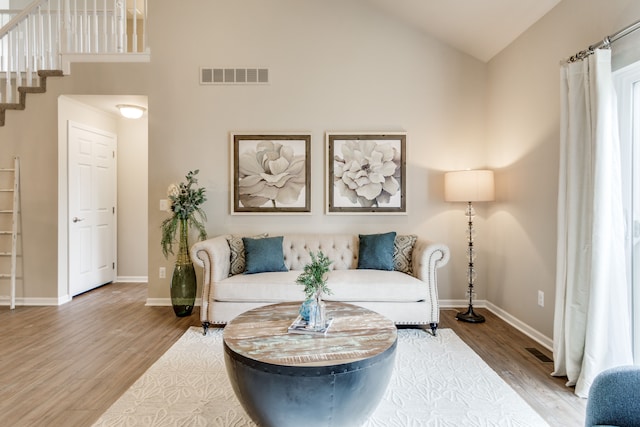 living room featuring hardwood / wood-style flooring and high vaulted ceiling