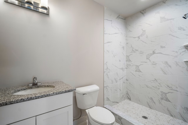 bathroom featuring vanity, toilet, and tiled shower