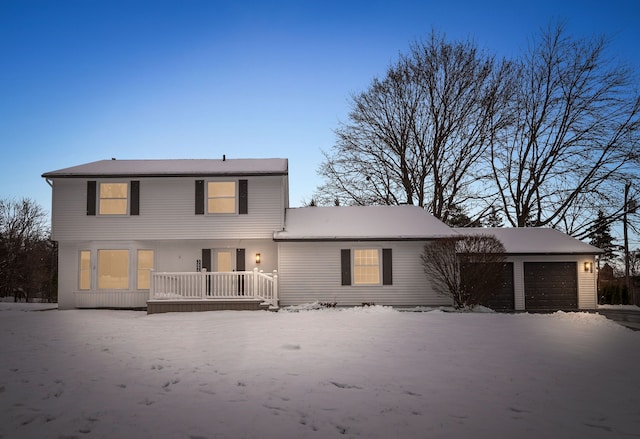 rear view of property featuring a porch and a garage