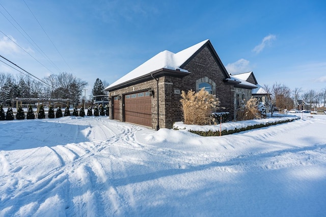 snow covered property with a garage