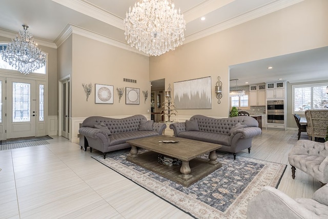 tiled living room with a high ceiling, an inviting chandelier, and ornamental molding