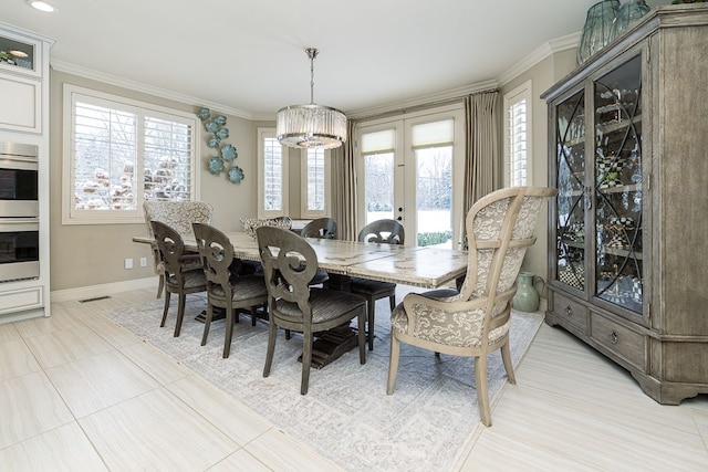 dining space featuring ornamental molding, french doors, and a notable chandelier