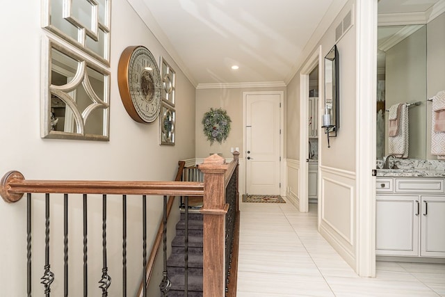 hallway with ornamental molding and light tile patterned flooring