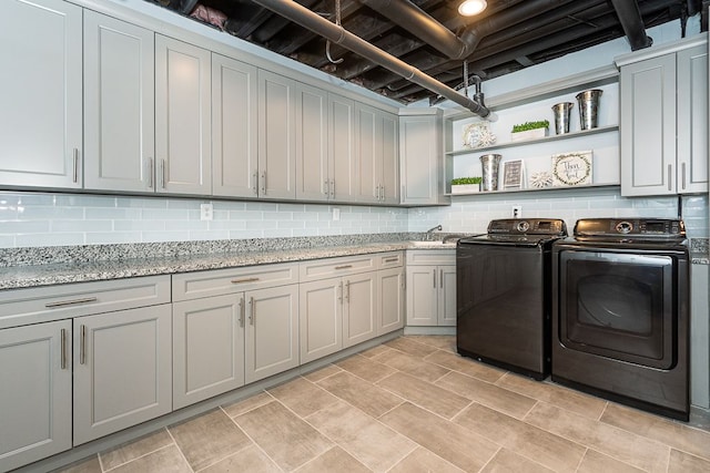 clothes washing area with sink, cabinets, and independent washer and dryer