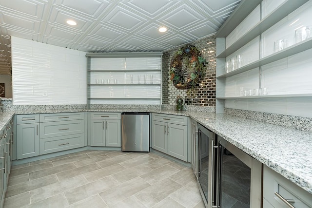 kitchen featuring fridge, beverage cooler, and light stone countertops