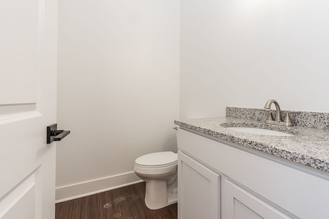 bathroom with hardwood / wood-style flooring, vanity, and toilet