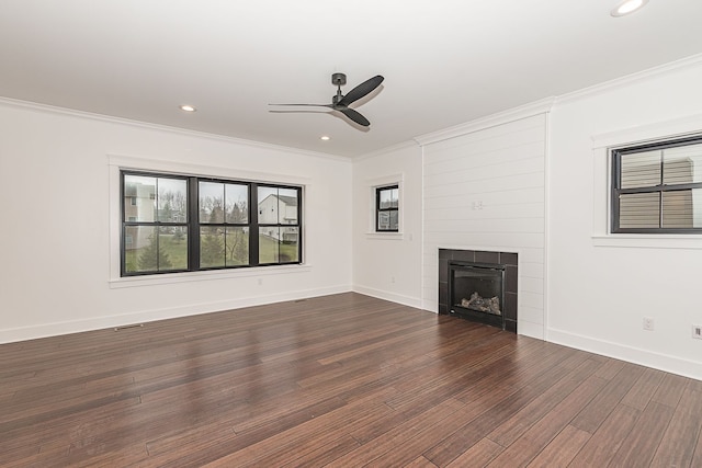 unfurnished living room with dark hardwood / wood-style flooring, ornamental molding, and a tile fireplace