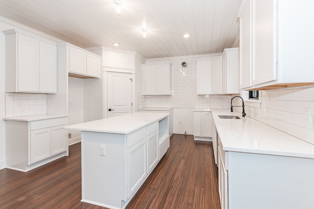 kitchen featuring white cabinets, dark hardwood / wood-style floors, a kitchen island, and sink