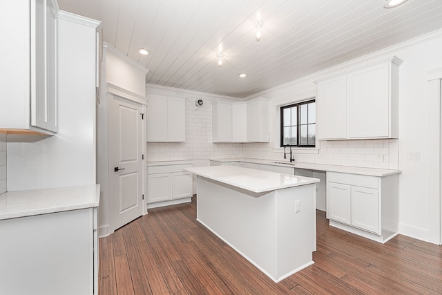 kitchen featuring dark hardwood / wood-style flooring, a center island, white cabinetry, and crown molding