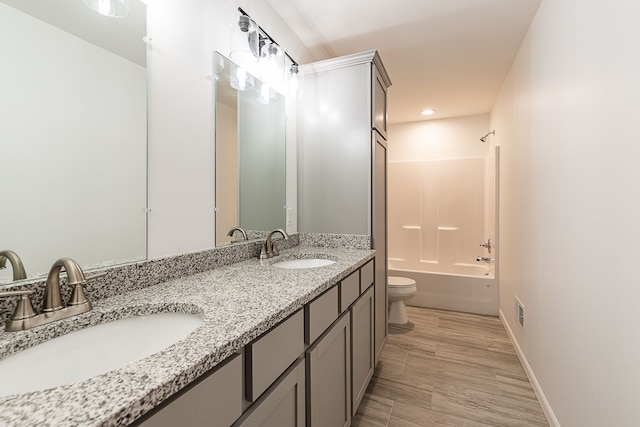 full bathroom featuring hardwood / wood-style flooring, shower / washtub combination, vanity, and toilet