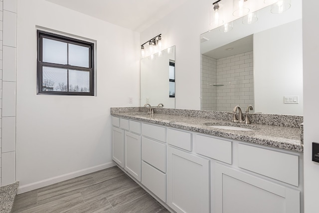 bathroom with tiled shower and vanity