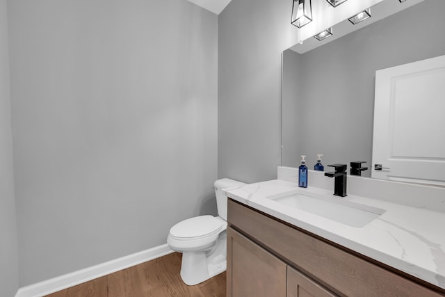 bathroom featuring vanity, hardwood / wood-style flooring, and toilet