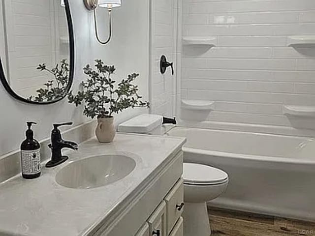 full bathroom with toilet, vanity, bathtub / shower combination, and hardwood / wood-style flooring