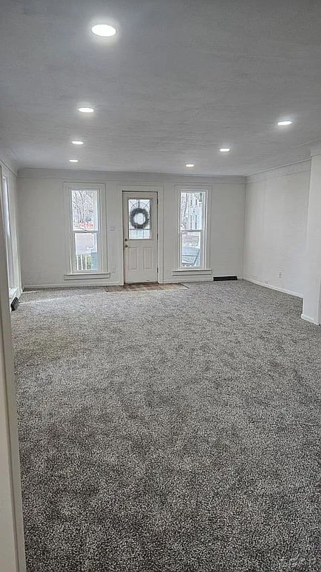 interior space featuring a healthy amount of sunlight, carpet floors, and a textured ceiling