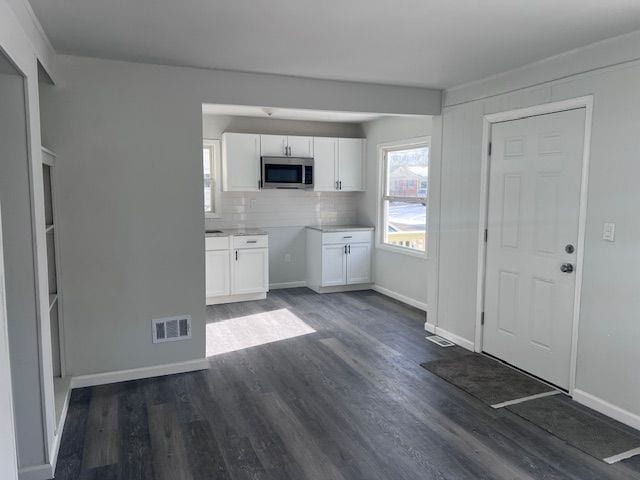 kitchen featuring white cabinets, backsplash, and dark hardwood / wood-style floors