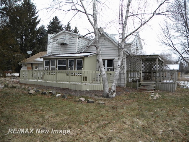 view of front of house featuring a sunroom, a front lawn, and a wooden deck