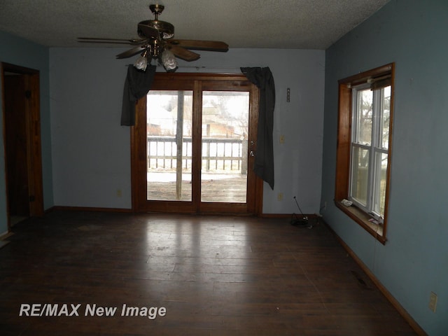 empty room featuring dark hardwood / wood-style flooring, a textured ceiling, and ceiling fan