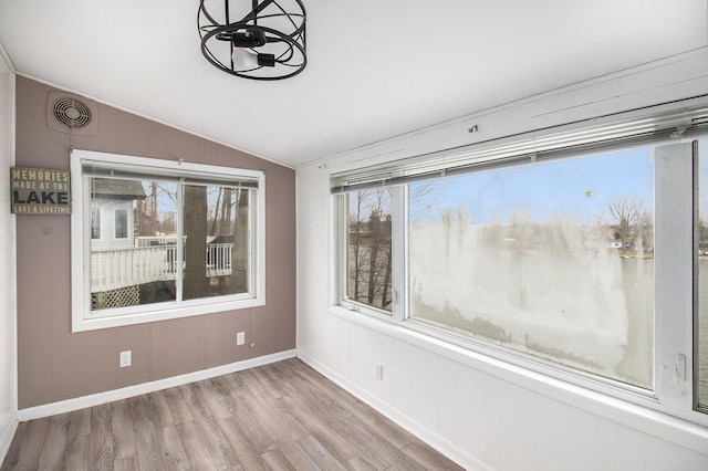 interior space with light hardwood / wood-style floors and vaulted ceiling