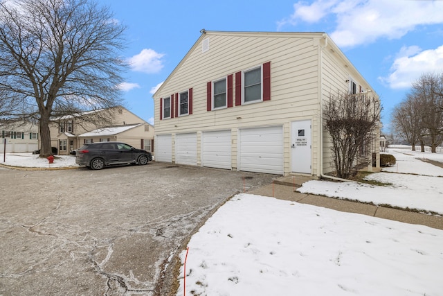 snow covered property featuring a garage