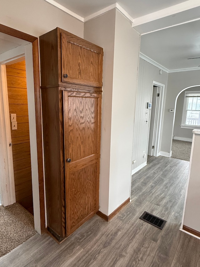 hallway with hardwood / wood-style floors and crown molding