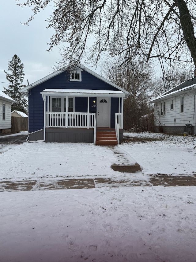 bungalow-style house with central AC unit and a porch