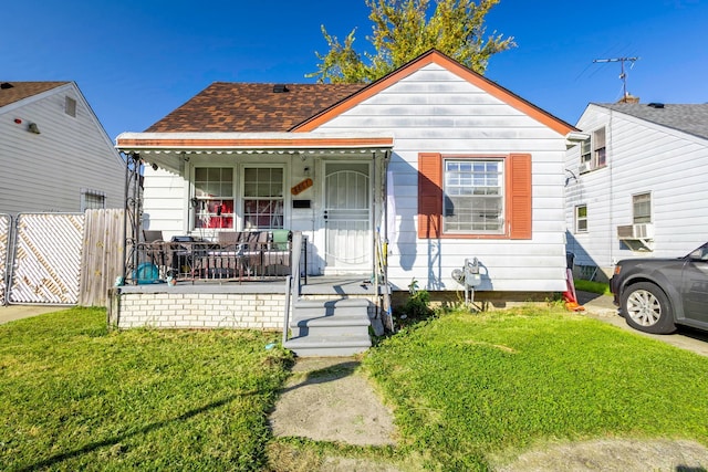 bungalow featuring cooling unit, a front yard, and covered porch