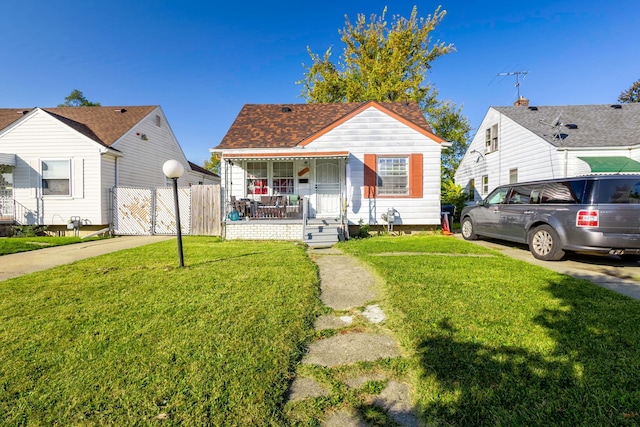 bungalow-style house with a front yard and covered porch