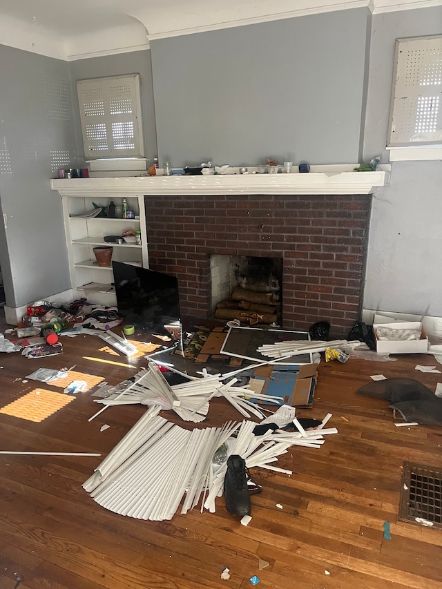 miscellaneous room featuring hardwood / wood-style floors, a brick fireplace, and crown molding