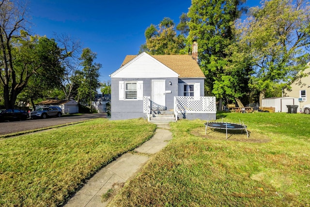 bungalow-style house featuring a trampoline and a front lawn