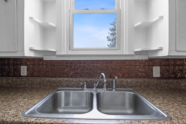 kitchen with decorative backsplash, sink, and white cabinetry