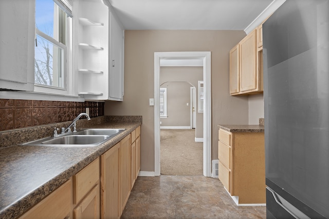 kitchen with light colored carpet, backsplash, sink, stainless steel refrigerator, and light brown cabinets