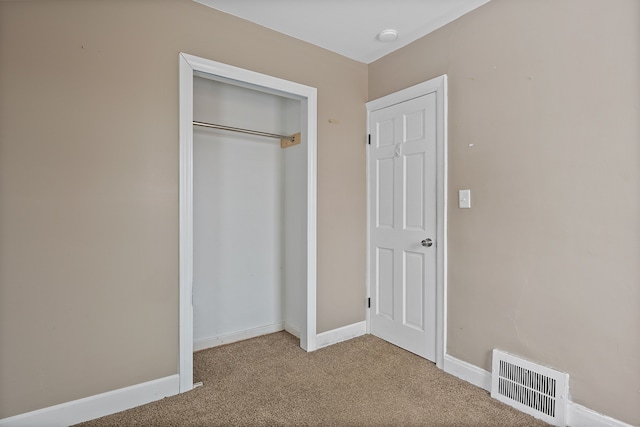 unfurnished bedroom with a closet and carpet flooring