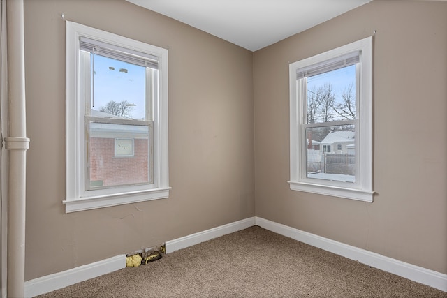 carpeted spare room featuring plenty of natural light