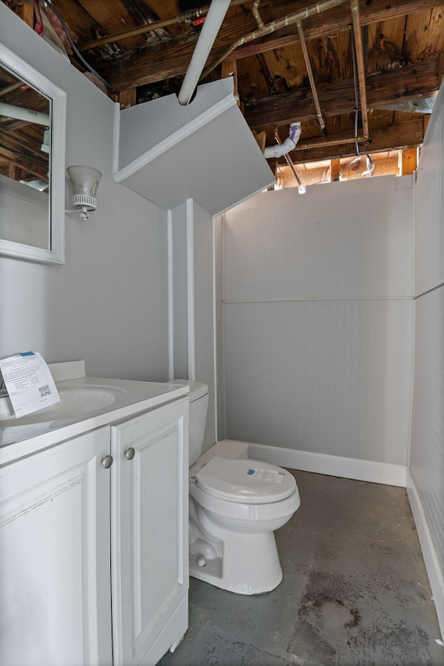 bathroom with toilet, vanity, and concrete flooring