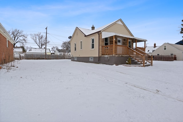 snow covered house with a porch