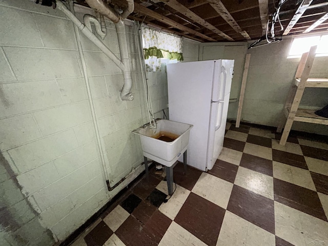 basement featuring white fridge and sink