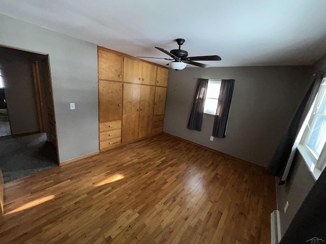 unfurnished bedroom featuring hardwood / wood-style flooring, ceiling fan, and a closet