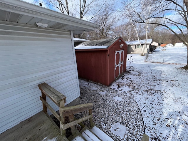 snowy yard featuring a storage unit