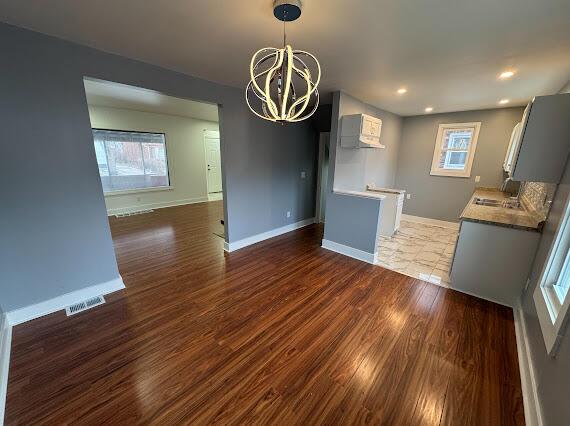 interior space featuring a wealth of natural light, sink, a chandelier, and dark hardwood / wood-style floors