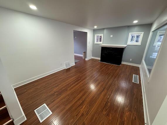 unfurnished living room featuring a fireplace and dark hardwood / wood-style floors