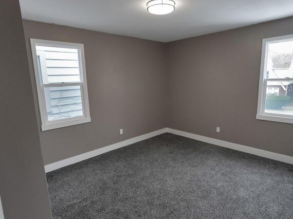 empty room featuring dark colored carpet