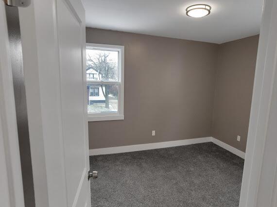 empty room with dark colored carpet