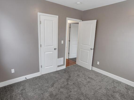 unfurnished bedroom featuring dark colored carpet