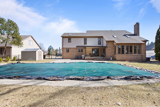 view of pool with a fenced in pool, fence, a shed, an outdoor structure, and a patio area