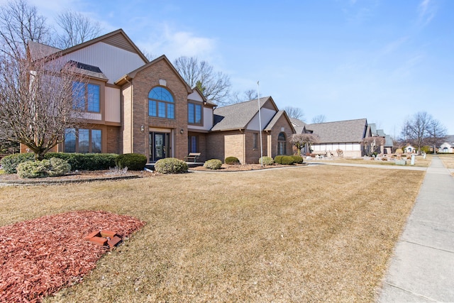 traditional-style house with brick siding and a front lawn