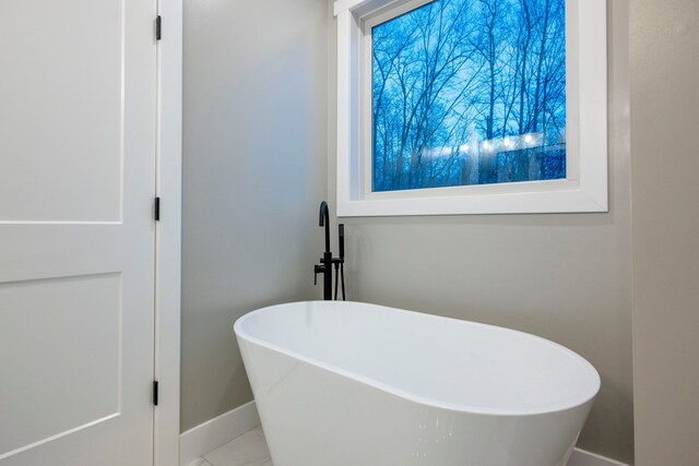 bathroom featuring a tub to relax in and tile patterned flooring