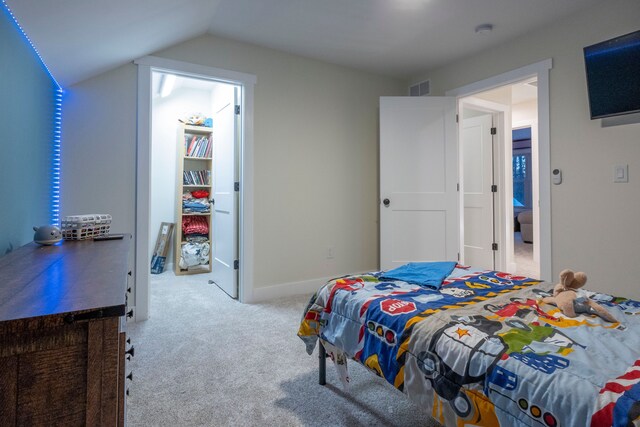 bedroom with vaulted ceiling and light carpet