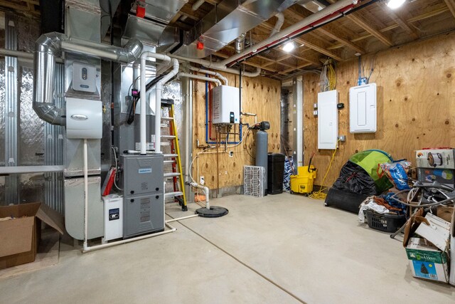 basement featuring electric panel, wooden walls, water heater, and heating unit