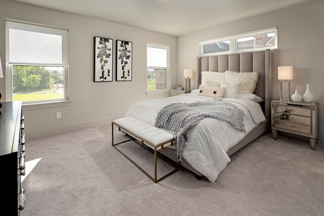 bedroom featuring light colored carpet and multiple windows