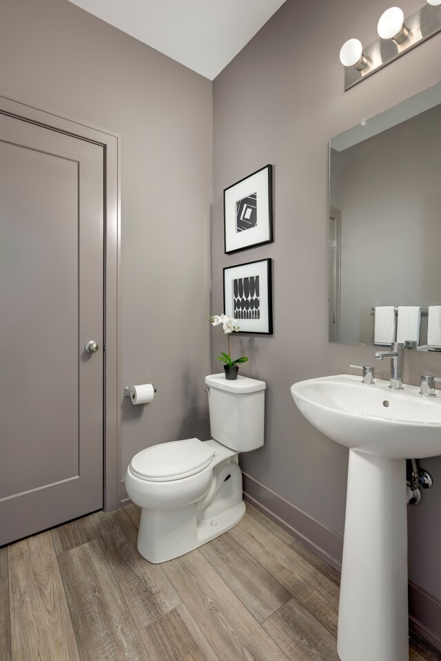 bathroom with hardwood / wood-style floors, toilet, and sink